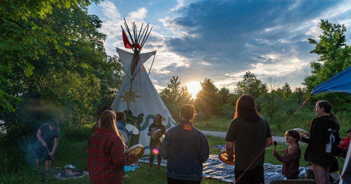 Land Back Camp in Willow River Park, people standing around an Indigenous Tent, photo taken by Bangishimo.