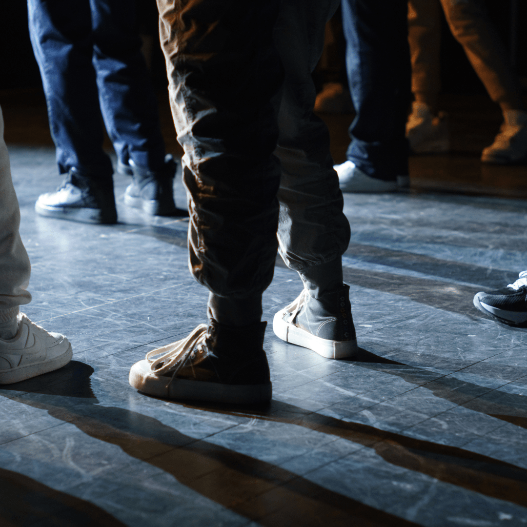 Image of legs backlit by stage lights.